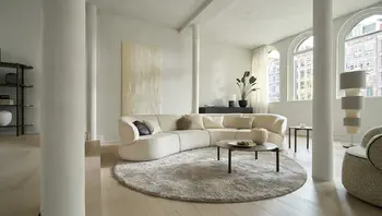 Großzügiges Sofa „Nimbo“ von Bielefelder Werkstätten in hellem Wohnraum mit runden Tischen und Teppich. Weiche Formen, Komfort und stilvolle Eleganz – Probesitzen bei himmlisch wohnen in Asbach-Bäumenheim.